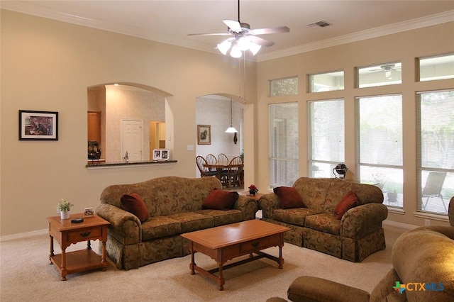 living room with ceiling fan, light carpet, and crown molding