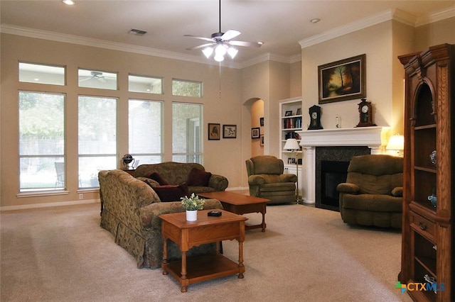 carpeted living room with ceiling fan and ornamental molding