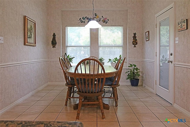 dining space featuring light tile patterned flooring and a chandelier