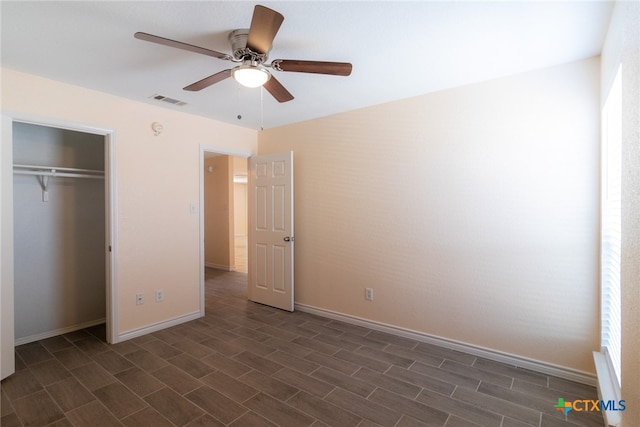 unfurnished bedroom with dark hardwood / wood-style flooring, ceiling fan, and a closet