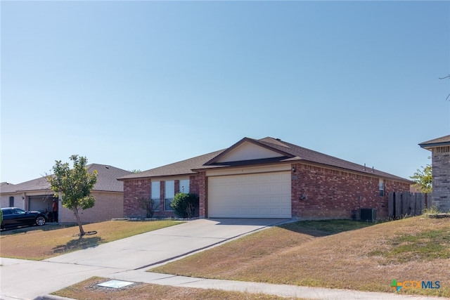 ranch-style house featuring central air condition unit, a garage, and a front yard