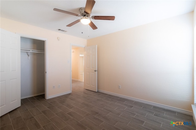 unfurnished bedroom featuring ceiling fan, dark hardwood / wood-style floors, and a closet