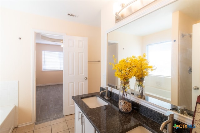 bathroom featuring tile patterned flooring, vanity, and a tub