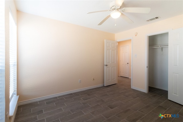 unfurnished bedroom featuring ceiling fan, a closet, and dark hardwood / wood-style flooring