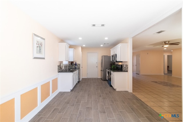 kitchen featuring tasteful backsplash, white cabinetry, light hardwood / wood-style floors, and stainless steel appliances