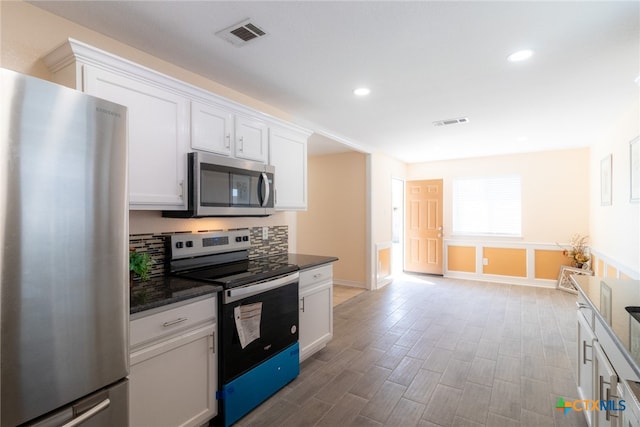 kitchen featuring white cabinets, appliances with stainless steel finishes, and light hardwood / wood-style floors