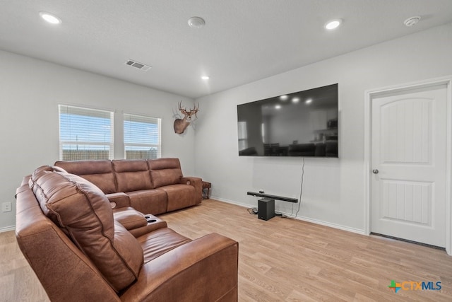 living room featuring a textured ceiling and light wood-type flooring