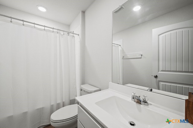 full bathroom with shower / bathtub combination with curtain, vanity, and toilet