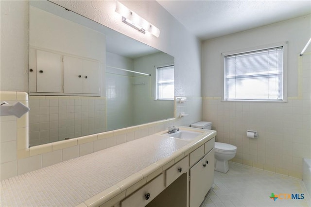 full bathroom featuring tile walls, a shower, toilet, tile patterned floors, and vanity