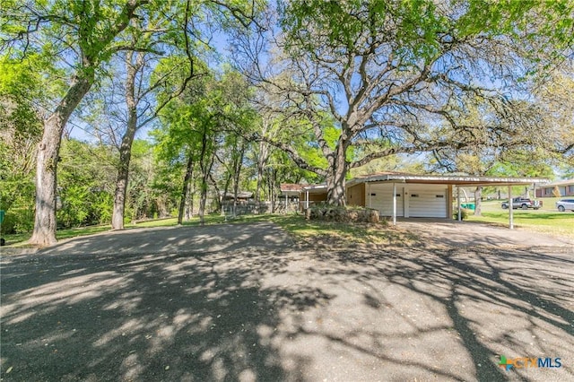 view of front of home featuring driveway, a carport, and a garage