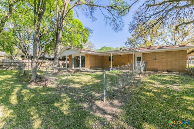 rear view of house with a yard and fence
