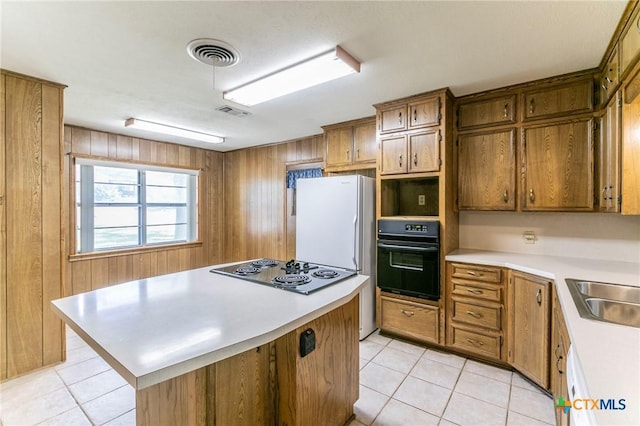 kitchen with light countertops, visible vents, brown cabinetry, and white appliances