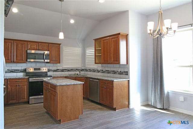 2734 Rock Rd, Troy, TX 76579 - kitchen featuring appliances with stainless steel finishes, tasteful backsplash, a chandelier, wood finished floors, and lofted ceiling
