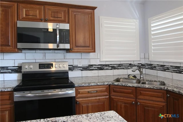2734 Rock Rd, Troy, TX 76579 - kitchen with appliances with stainless steel finishes, tasteful backsplash, and light stone counters