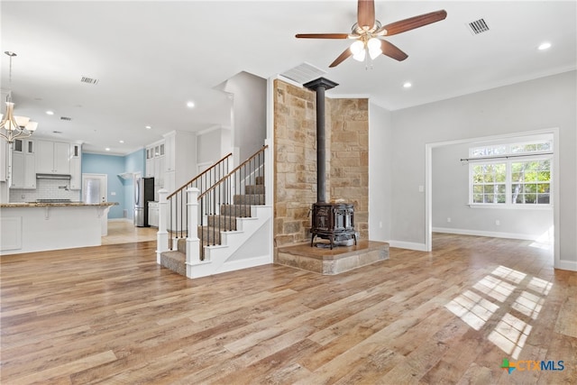 unfurnished living room featuring light hardwood / wood-style flooring, a notable chandelier, and crown molding