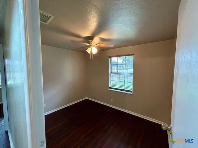 305 Larkspur St, Victoria, TX 77904 - empty room with a ceiling fan, baseboards, visible vents, dark wood-type flooring, and a textured ceiling