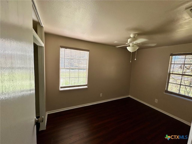 spare room with dark wood-type flooring, ceiling fan, and a textured ceiling