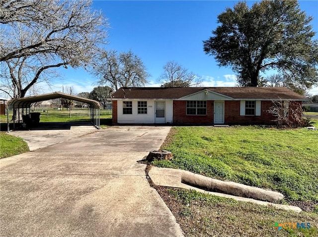 305 Larkspur St, Victoria, TX 77904 - view of front of home featuring concrete driveway, a detached carport, a front yard, and brick siding