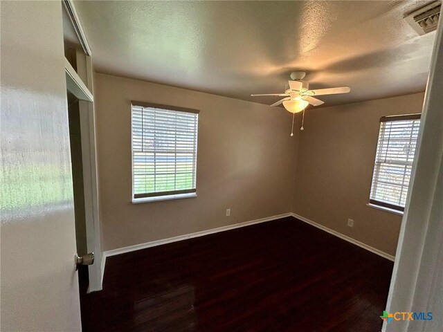 unfurnished room with dark hardwood / wood-style flooring, a textured ceiling, and ceiling fan