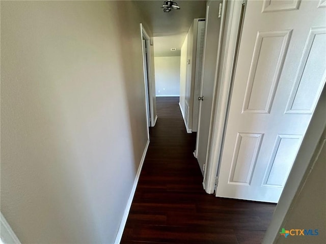 hallway with dark hardwood / wood-style flooring