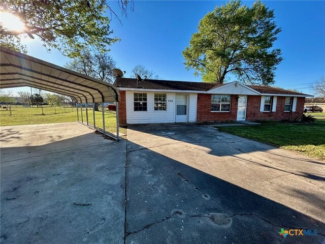 ranch-style home featuring a carport, a front yard, and central air condition unit