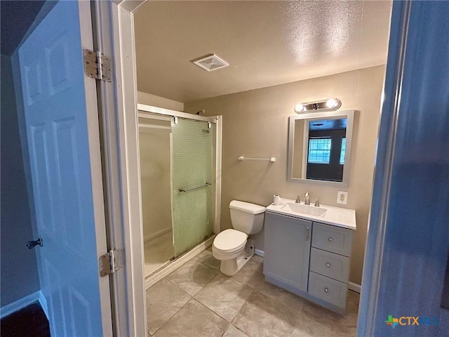 bathroom with an enclosed shower, vanity, tile patterned floors, and toilet