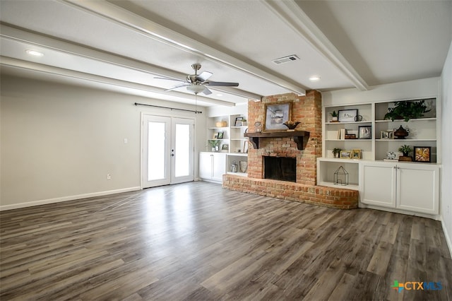 unfurnished living room with french doors, a fireplace, beam ceiling, dark hardwood / wood-style flooring, and ceiling fan