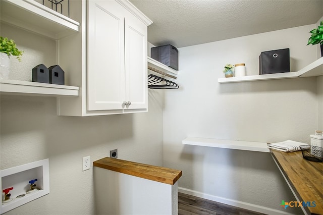 laundry room with cabinets, a textured ceiling, electric dryer hookup, dark wood-type flooring, and hookup for a washing machine