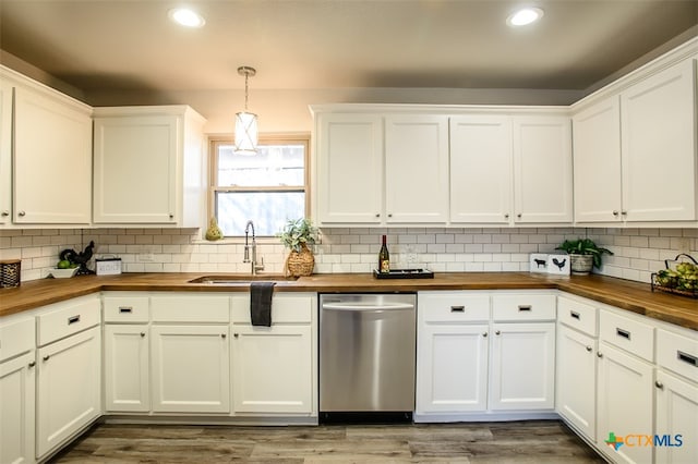 kitchen featuring wood-type flooring, hanging light fixtures, sink, butcher block countertops, and stainless steel dishwasher