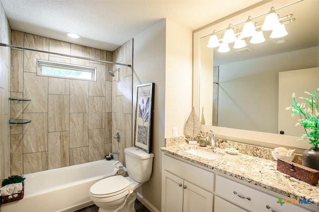 full bathroom featuring vanity, toilet, a textured ceiling, and tiled shower / bath combo