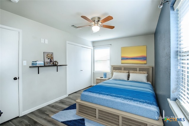 bedroom with dark wood-type flooring, a closet, and ceiling fan