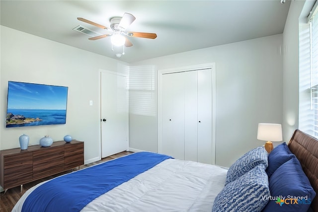 bedroom with dark hardwood / wood-style flooring, a closet, and ceiling fan