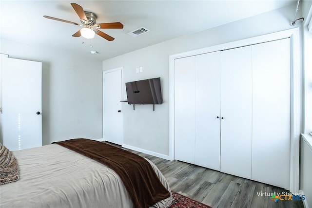 bedroom featuring ceiling fan, wood-type flooring, and a closet