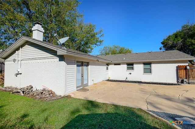 rear view of property with a yard and a patio