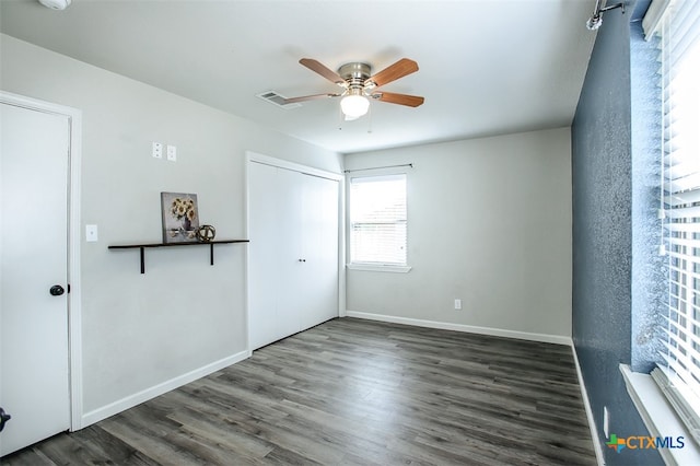 spare room with dark wood-type flooring and ceiling fan