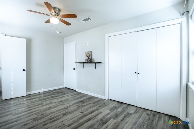 unfurnished bedroom with dark wood-type flooring, a closet, and ceiling fan