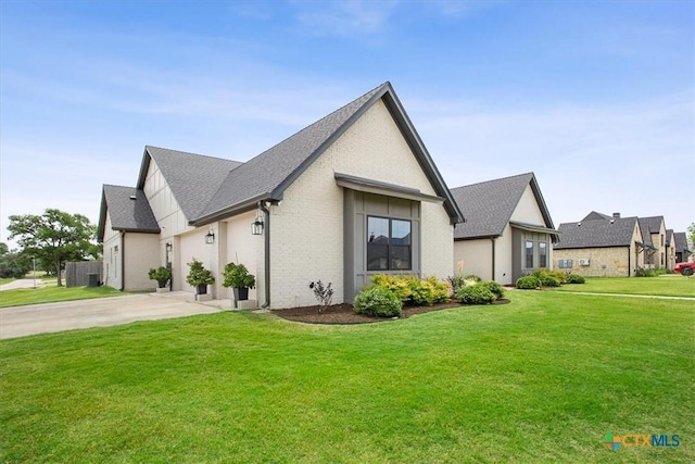 127 Cumberland Dr, Belton, TX 76513 - view of property exterior with concrete driveway, a shingled roof, a lawn, and brick siding