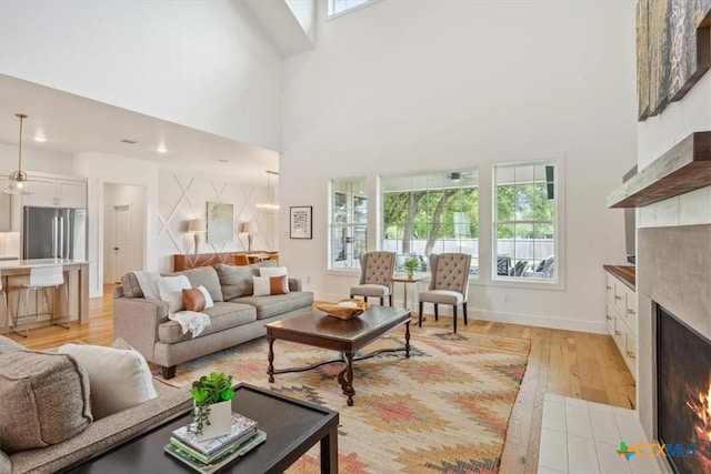 127 Cumberland Dr, Belton, TX 76513 - living area with a tile fireplace, a towering ceiling, light wood-style floors, baseboards, and recessed lighting
