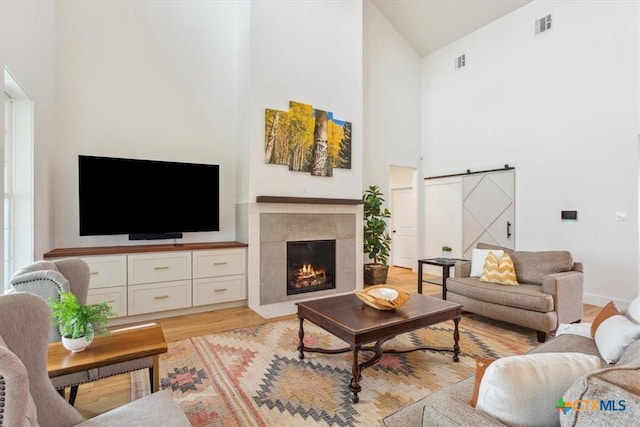 127 Cumberland Dr, Belton, TX 76513 - living area featuring high vaulted ceiling, a barn door, light wood finished floors, and a high end fireplace