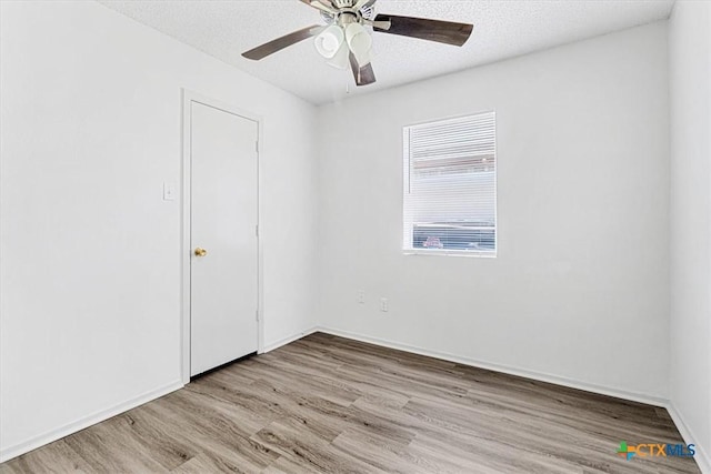 spare room featuring a textured ceiling, ceiling fan, and light hardwood / wood-style flooring