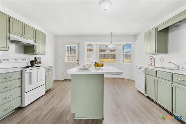 kitchen with sink, green cabinets, white appliances, light wood-type flooring, and a kitchen island