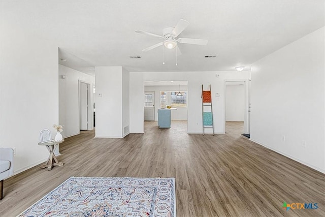 unfurnished living room with ceiling fan and wood-type flooring