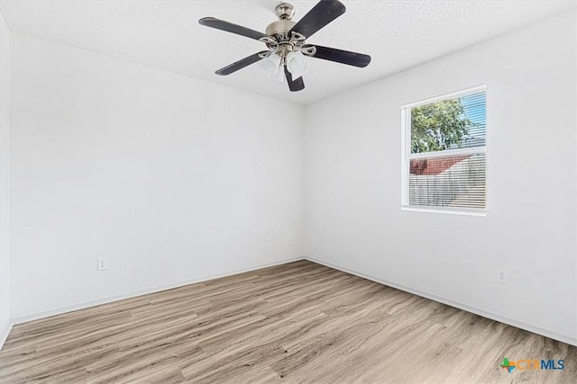 spare room with ceiling fan, light wood-type flooring, and a textured ceiling