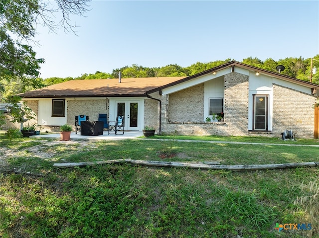 back of house with a lawn, french doors, and a patio area