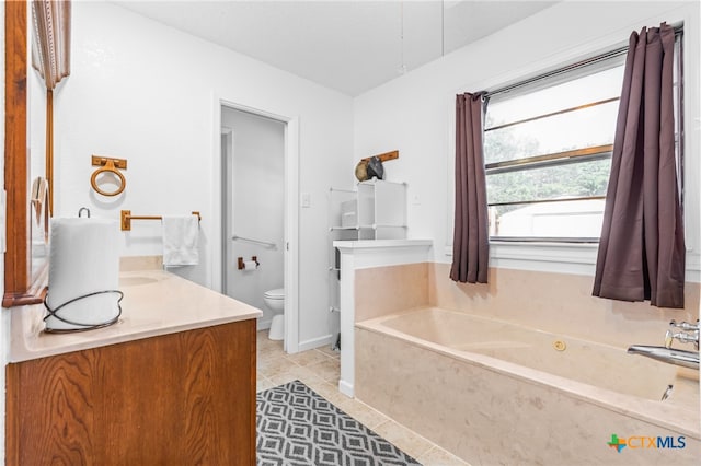 bathroom featuring vanity, tile patterned flooring, toilet, and a washtub