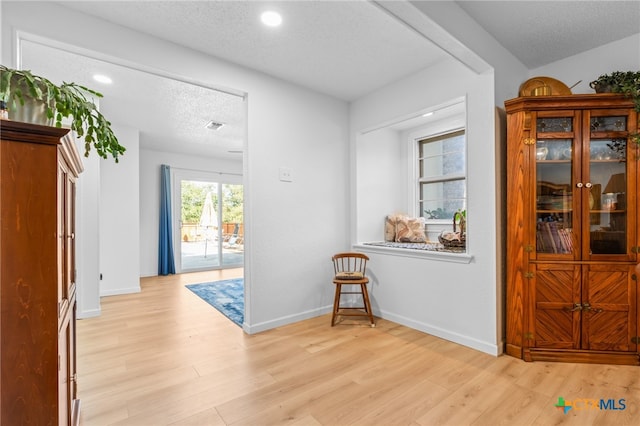 foyer with light hardwood / wood-style flooring and a textured ceiling