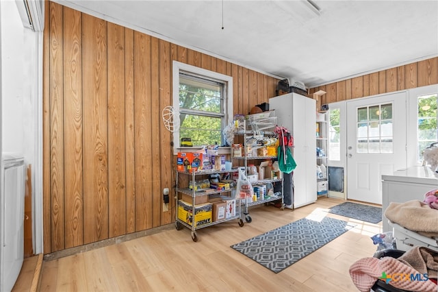 interior space with light wood-type flooring, wooden walls, and plenty of natural light