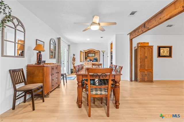 dining room featuring a textured ceiling, light wood-type flooring, and ceiling fan