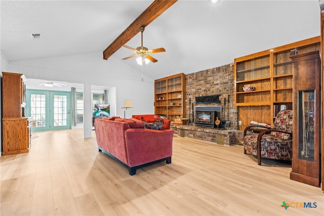 living room with french doors, vaulted ceiling with beams, a wood stove, ceiling fan, and light hardwood / wood-style flooring