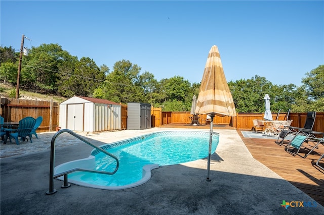 view of swimming pool featuring a shed and a patio area